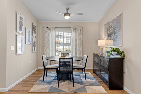 A dining room with a table set for four.