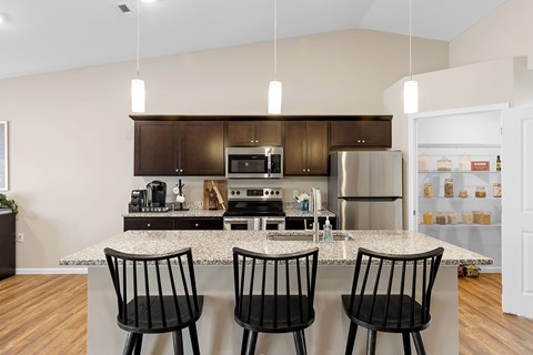 A kitchen with brown cabinets and a granite countertop.