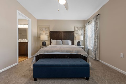 A bedroom with a large bed and a ceiling fan.
