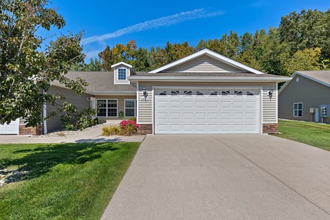 A house with a grey roof and a white garage door.