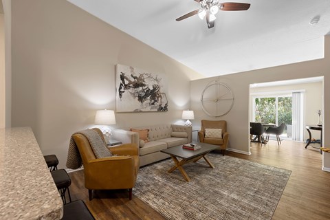 A living room with a couch, chairs, and a rug.