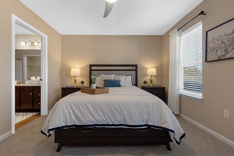 A bedroom with a large bed and a ceiling fan.
