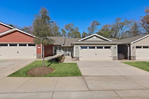 A house with a red roof and a brown garage door.