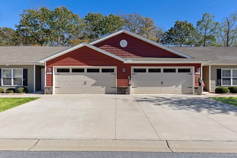 A two-car garage with a red brick exterior and a grey roof.