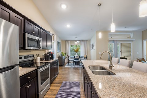 A kitchen with a stainless steel refrigerator and a sink.