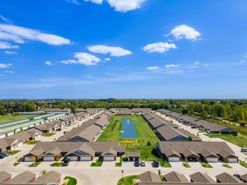 A large suburban neighborhood with a swimming pool and a clear blue sky.
