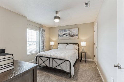 A bedroom with a large bed and a painting on the wall.