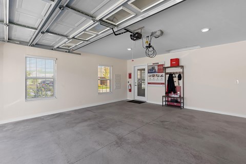 A spacious room with a concrete floor and a ceiling with exposed pipes.