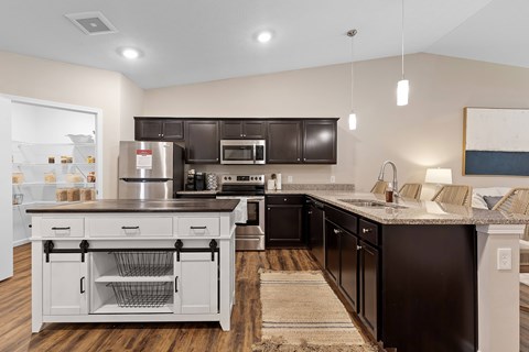 A modern kitchen with dark brown cabinets and a white island.