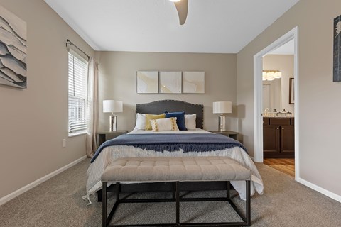 A bedroom with a bed, nightstands, and a ceiling fan.