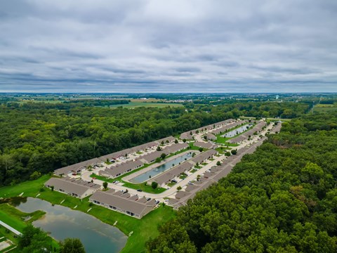 A bird's eye view of a resort with a swimming pool and a lake.