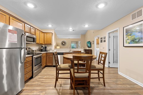 A kitchen with a table and chairs.