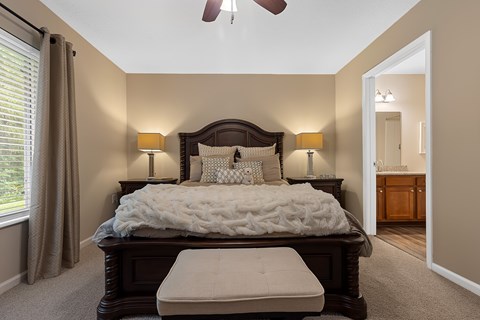 A bedroom with a large bed and a ceiling fan.