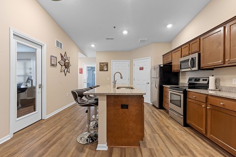A kitchen with a wooden island and stainless steel appliances.