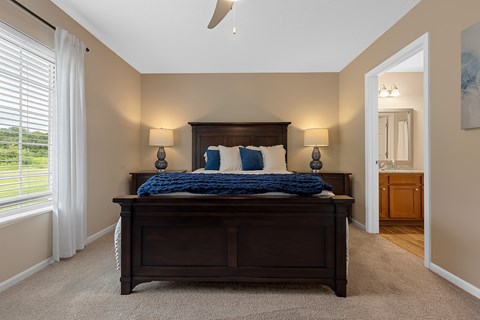 A bedroom with a large bed and a ceiling fan.