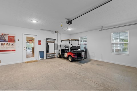A room with a red and black golf cart inside.
