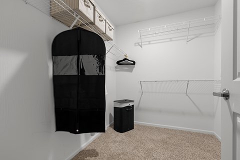 A room with a black closet and a trash can.