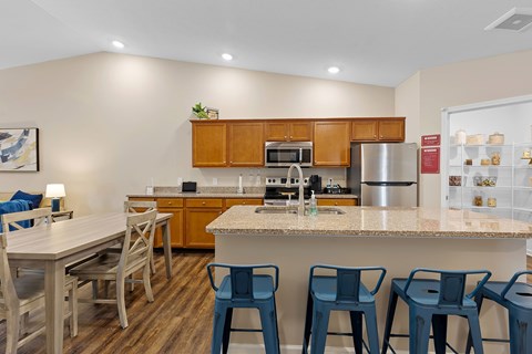 A kitchen with a table and chairs.