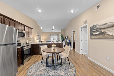 A kitchen with a table and chairs in the middle of the room.