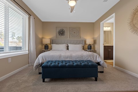 A bedroom with a large bed and a bench in front of it.