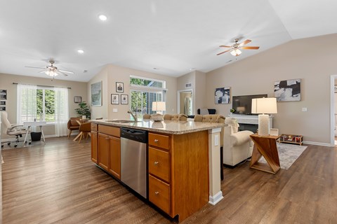 A kitchen with wooden cabinets and a stainless steel dishwasher.