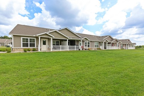 A row of houses with green lawns in front.