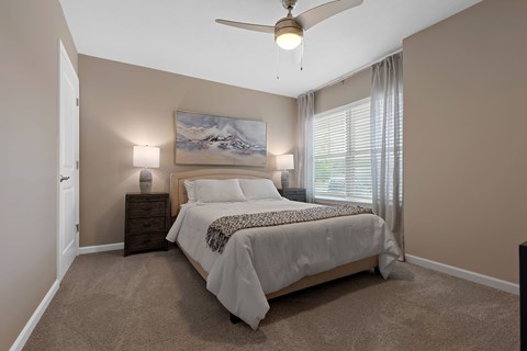 A bedroom with a large bed and a painting on the wall.