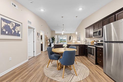 A kitchen with a table and chairs in the middle of the room.
