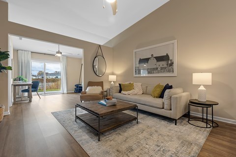 A living room with a white couch, a coffee table, and a painting on the wall.