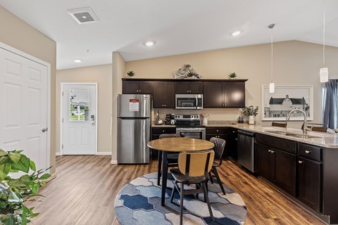 A kitchen with a table and chairs in the middle of the room.