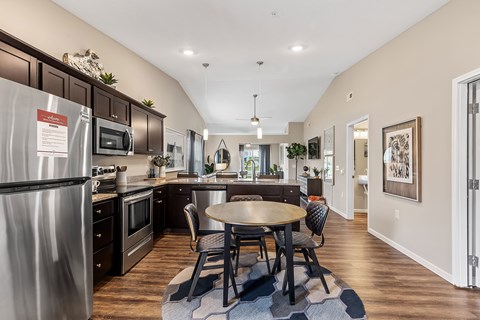A kitchen with a table and chairs in the middle of the room.