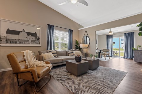 A living room with a brown leather chair and a grey sofa.