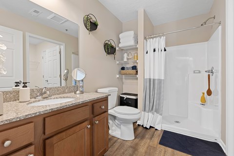 A bathroom with a white toilet and a white shower.