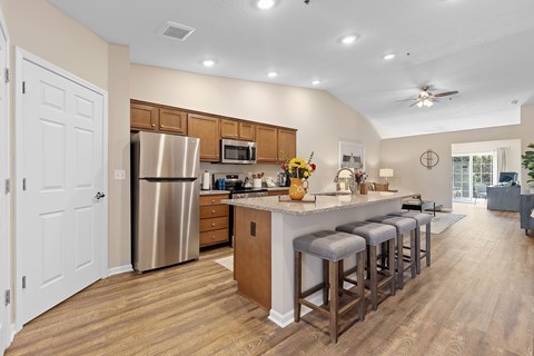 A kitchen with a bar stool and a fridge.