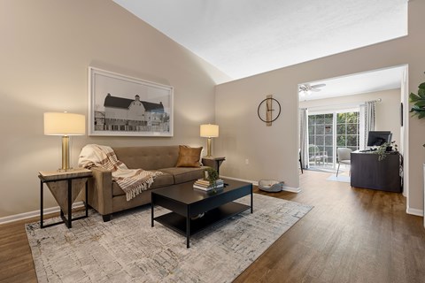 A living room with a couch, a coffee table, and a painting on the wall.