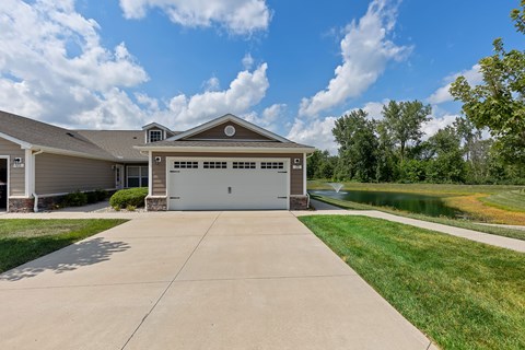 A house with a garage and a driveway in front of it.