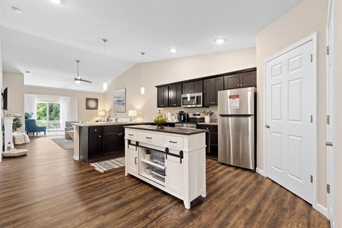 A modern kitchen with dark brown cabinets and white appliances.