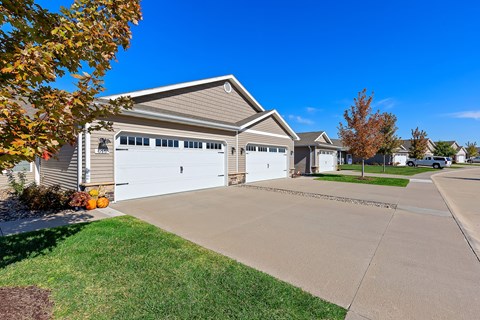 A house with a grey roof and two white garage doors.