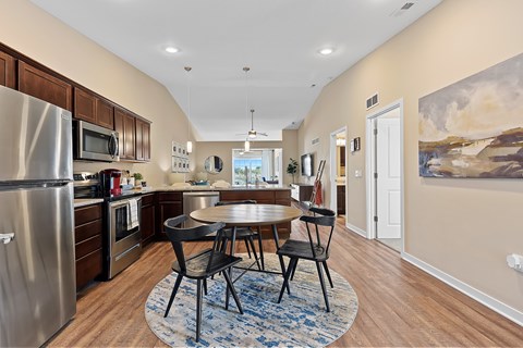 A kitchen with a table and chairs in the middle of the room.