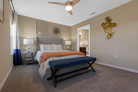 A bedroom with a large bed and a ceiling fan.
