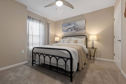 A bedroom with a large bed and a painting on the wall.