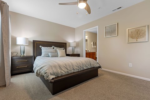 A bedroom with a large bed and a ceiling fan.