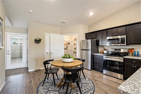 A kitchen with a table and chairs in the middle of the room.