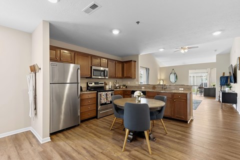 A kitchen with a table and chairs in the middle.