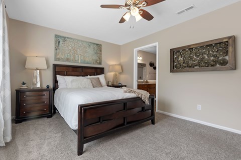 A bedroom with a large bed and a ceiling fan.