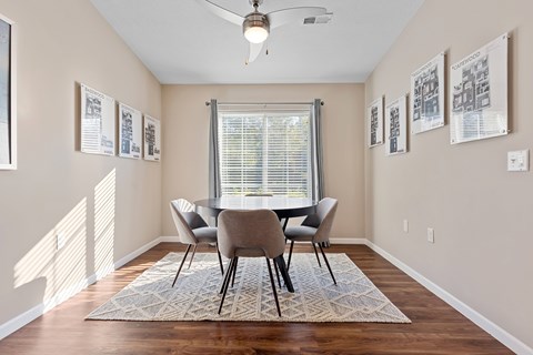 A dining room with a table and chairs.