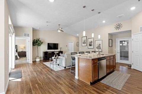 A modern kitchen with wooden floors and a central island.