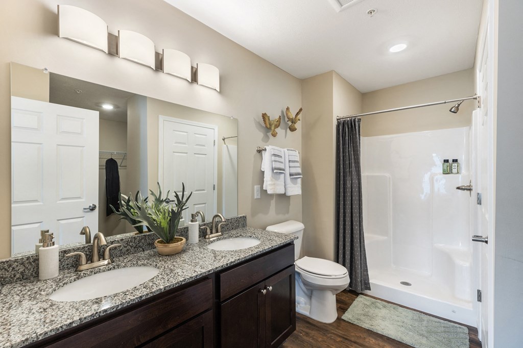 a bathroom with two sinks and a shower and a toilet