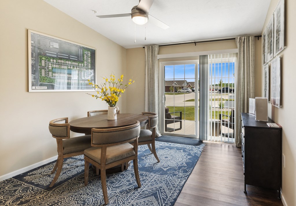 a dining room with a table and chairs and a sliding glass door