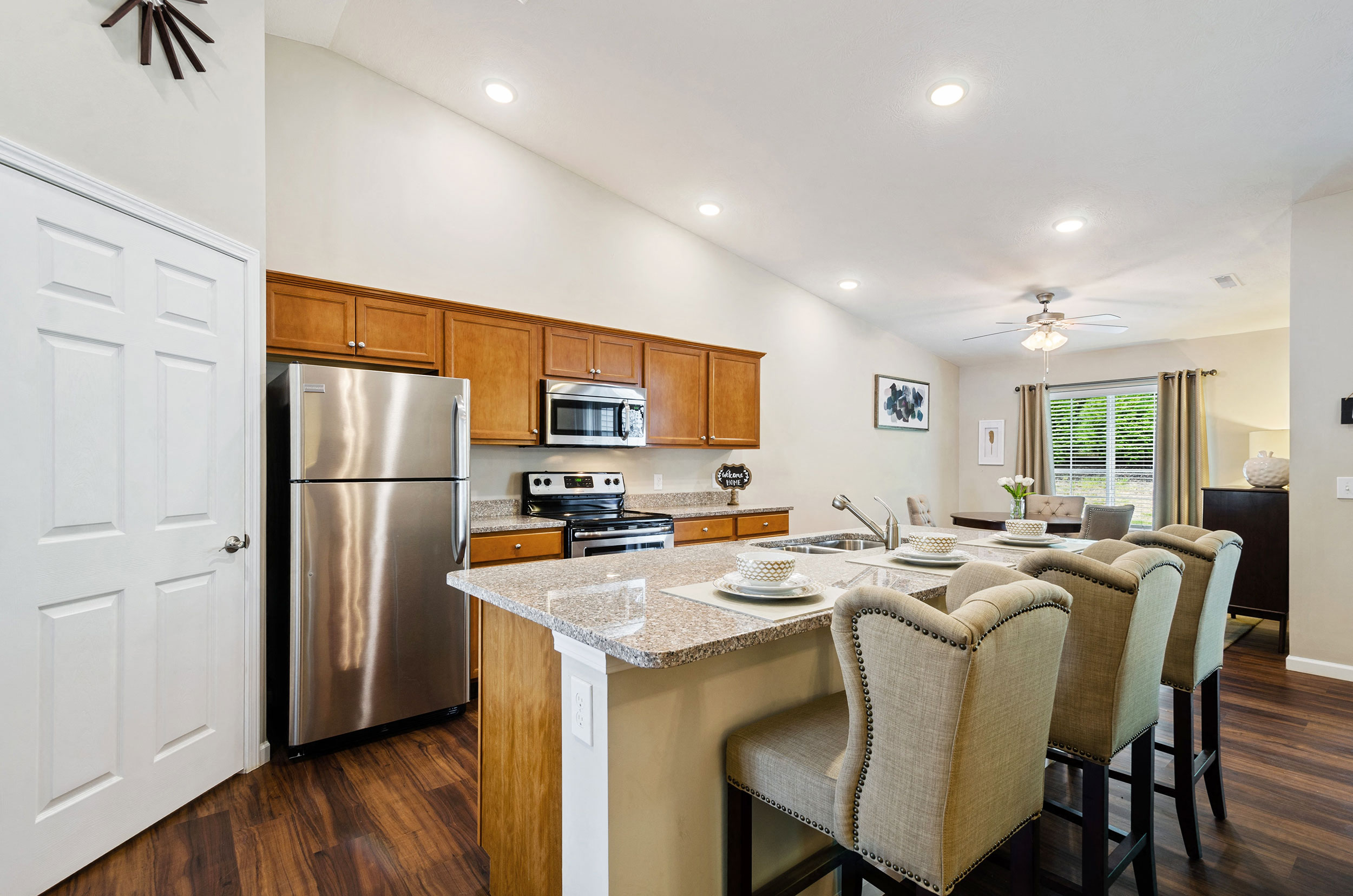a kitchen and dining room with a stainless steel refrigerator